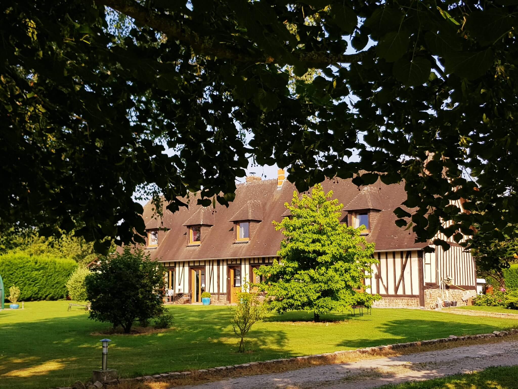 Longère normande dans un écrin de verdure.