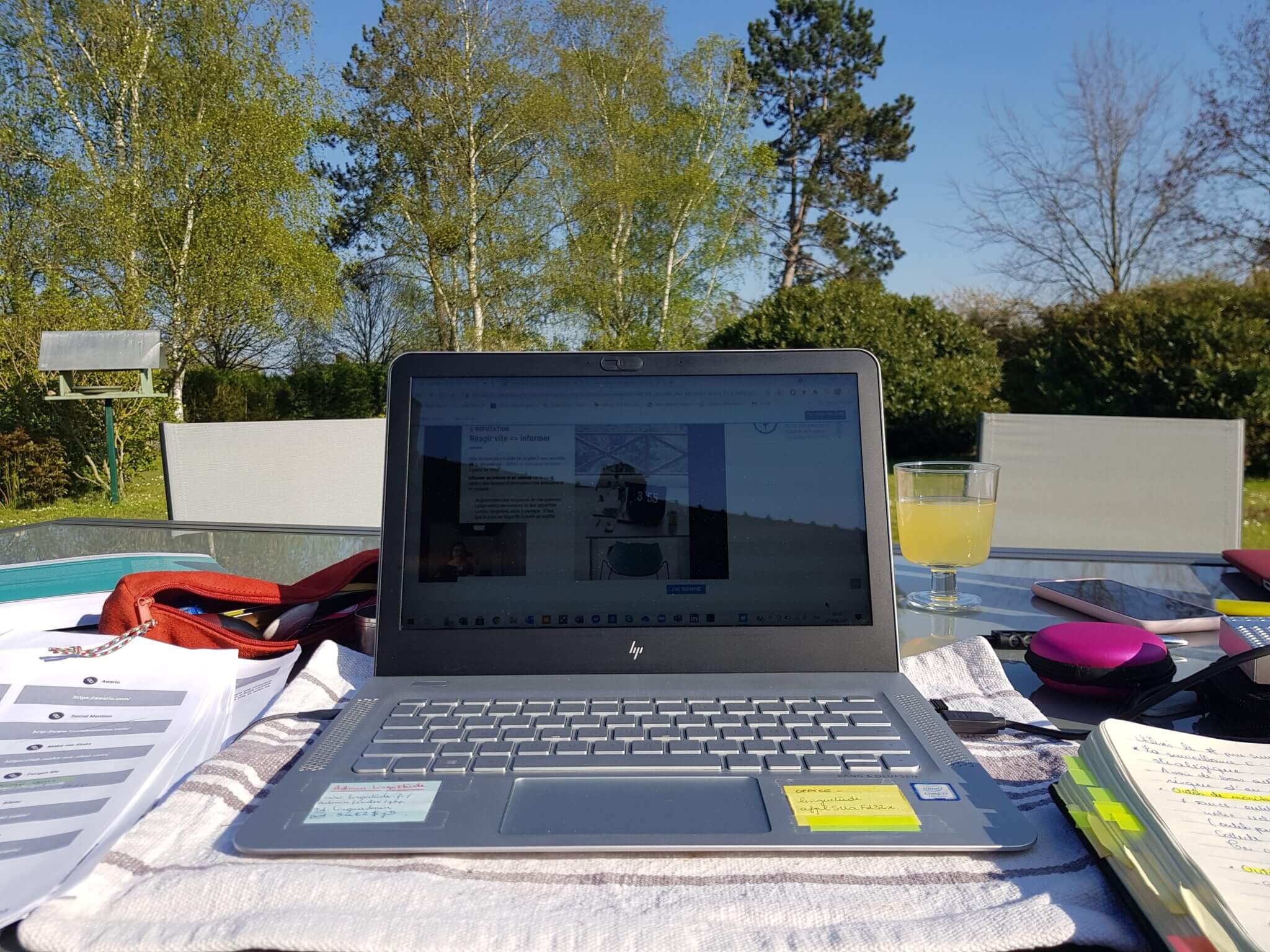 Ordinateur sur une table dans un jardin.